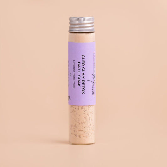 Clay Detox Bath Soak with lavender and ylang ylang in a glass tube on a beige background