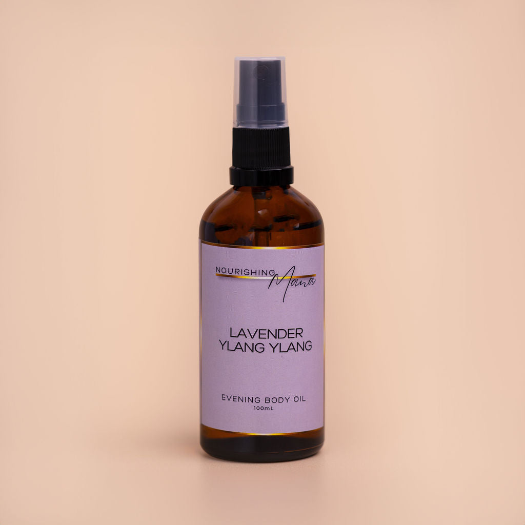 Nourishing Mana Lavender Ylang Ylang Evening Body Oil in a 100ml amber glass spray bottle on a beige background.