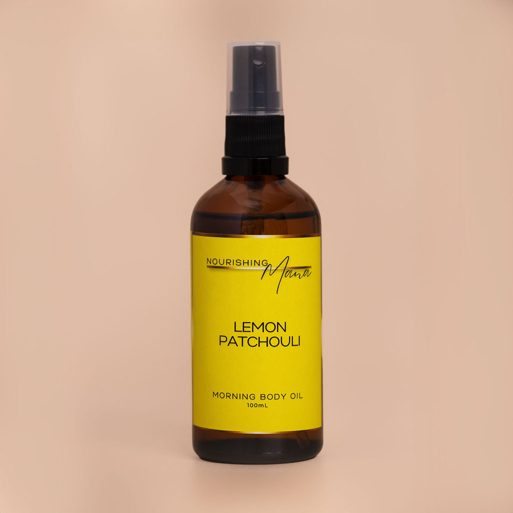 Nourishing Mana Lemon Patchouli Morning Body Oil in a 100ml amber glass spray bottle on a beige background.
