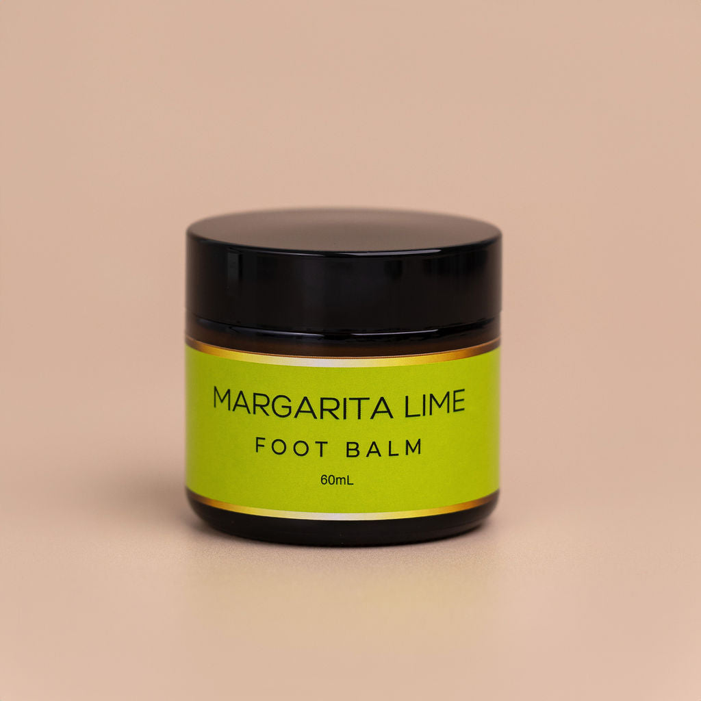 Nourishing Mana Margarita Lime Foot Balm in a 60ml amber glass jar with a black lid on a beige background.