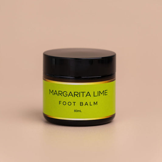 Nourishing Mana Margarita Lime Foot Balm in a 60ml amber glass jar with a black lid on a beige background.