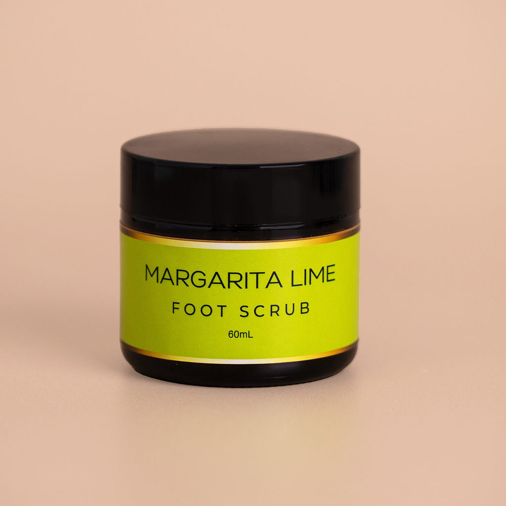 Nourishing Mana Margarita Lime Foot Scrub in a 60ml amber glass jar with a black lid on a beige background.